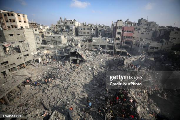 People check buildings destroyed in an Israeli strike on the Bureij refugee camp in the central Gaza Strip on November 2 as battles between Israel...