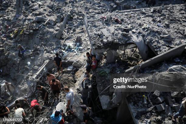 People check buildings destroyed in an Israeli strike on the Bureij refugee camp in the central Gaza Strip on November 2 as battles between Israel...