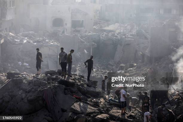 People check buildings destroyed in an Israeli strike on the Bureij refugee camp in the central Gaza Strip on November 2 as battles between Israel...
