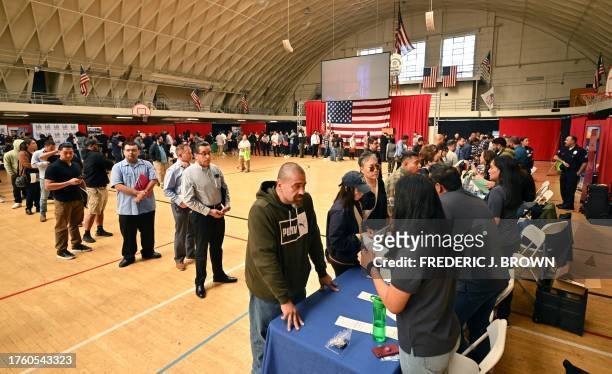 People wait in line for a chance to speak with prospective employers during a City of Los Angeles career fair offering to fill vacancies in more than...