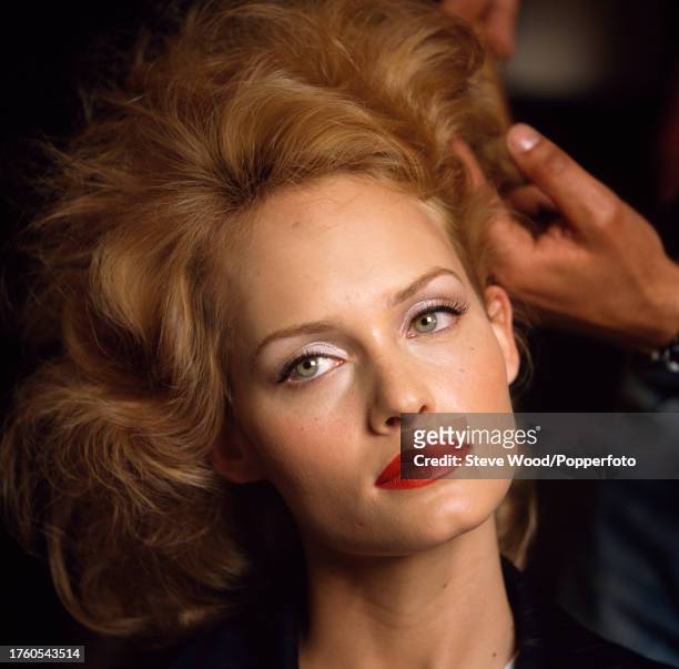 American model and actress Amber Valletta having her hair styled backstage at a Chanel fashion show, circa 1996.