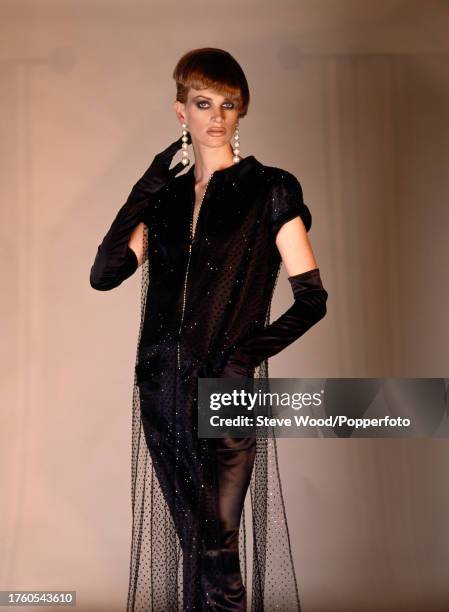 American supermodel Kristen McMenamy modelling a black mesh dress with diamante and long black gloves for the Italian fashion house Valentino, circa...