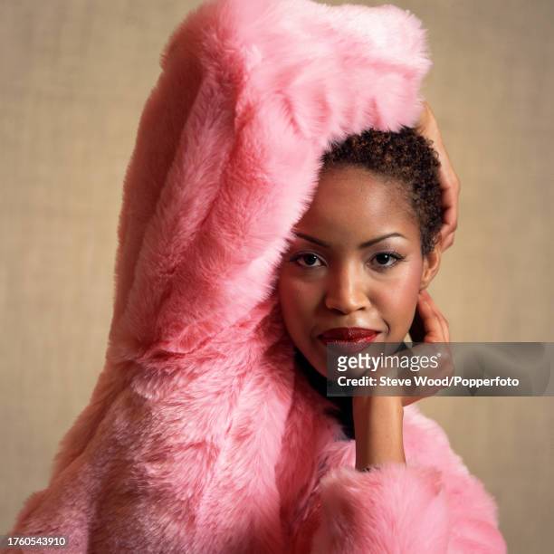 Jamaican supermodel Georgianna Robertson poses in a pink faux fur jacket, backstage at a Paco Rabanne fashion show, circa 1995.