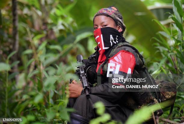 Member of the of the National Liberation Army takes a rest near the Baudo river in Choco province, Colombia on October 26, 2023. In the jungle that...