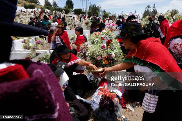 Families come together to share their food and remember their deceased in the cemetery in Salasaca, Ecuador, on November 2, 2023.