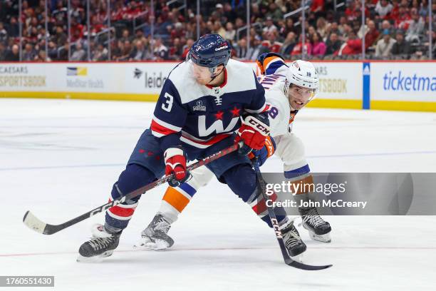 Nick Jensen of the Washington Capitals protects the puck from a pressuring Pierre Engvall of the New York Islanders during a game at Capital One...