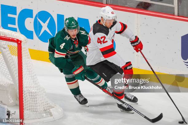 Curtis Lazar of the New Jersey Devils skates with the puck while Jon Merrill of the Minnesota Wild defends during the game at the Xcel Energy Center...