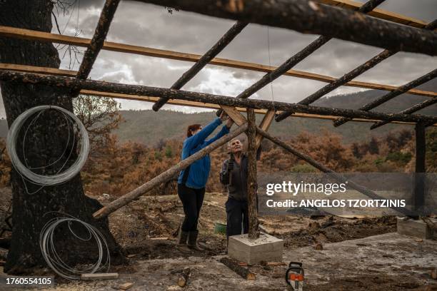 Athanassia Pistola and Thanassis Pistolas rebuild their burnt sheepfold after wildfire in a forest in the Evros region, near the village of Dadia, on...