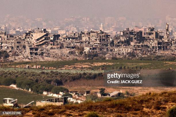 This picture taken on November 3, 2023 from a position along the border with the Gaza Strip in southern Israel shows buildings destroyed by Israeli...
