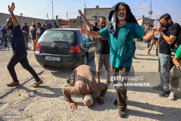 Palestinian workers, who were stranded in Israel since the October 7 attacks, react after crossing back into the Gaza Strip at the Kerem Shalom...