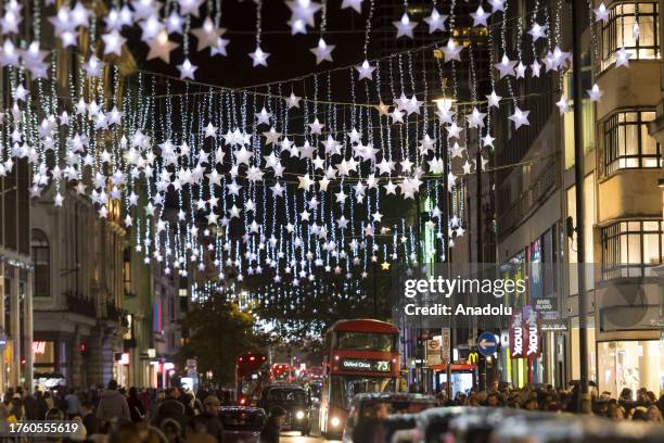 Shoppers walk in Oxford Street as the first Christmas lights installation of the festive season is switched on along the famous shopping thoroughfare...