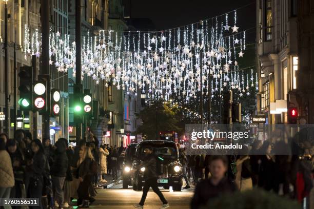 Shoppers walk in Oxford Street as the first Christmas lights installation of the festive season is switched on along the famous shopping thoroughfare...