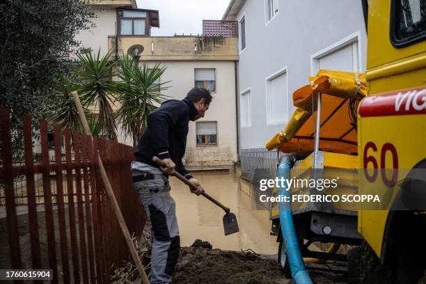 Man cleans mud near a flooded basement in Montemurlo, near Prato, after heavy rain last night, on November 3, 2023. Storm Ciaran hit Tuscany late on...