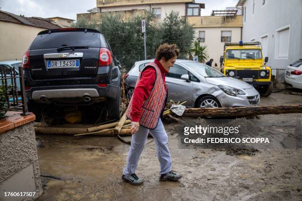 Woman walks past debris and damaged cars in Montemurlo, near Prato, after heavy rain last night, on November 3, 2023. Storm Ciaran hit Tuscany late...