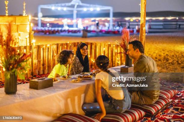 middle eastern family enjoying dinner in the desert in dubai - dubai sunset desert stock pictures, royalty-free photos & images