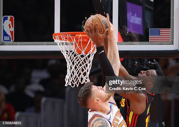 Isaiah Hartenstein of the New York Knicks defends against Onyeka Okongwu of the Atlanta Hawks during the first quarter at State Farm Arena on October...