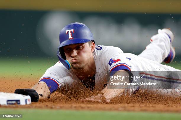 Corey Seager of the Texas Rangers slides into third base in the third inning against the Arizona Diamondbacks during Game One of the World Series at...