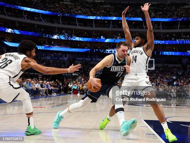 Luka Doncic of the Dallas Mavericks drives the ball between Spencer Dinwiddie and Cam Thomas of the Brooklyn Nets in the second quarter at American...