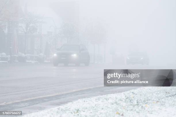 November 2023, Baden-Württemberg, Feldberg: Cars drive on a road on the Feldberg in the first snow. The first snowflakes of this fall have fallen on...