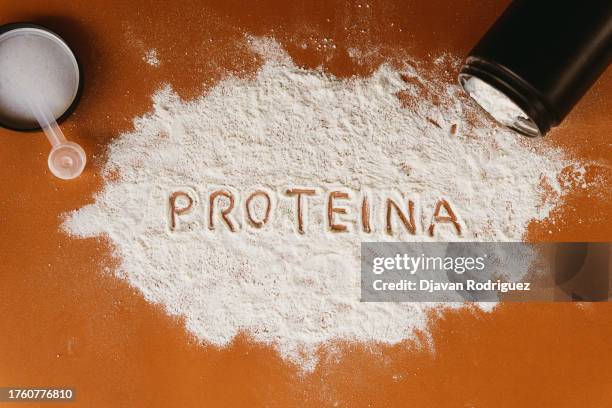 powder scattered with the text written in spanish 'creatina'. - protein shake stock-fotos und bilder