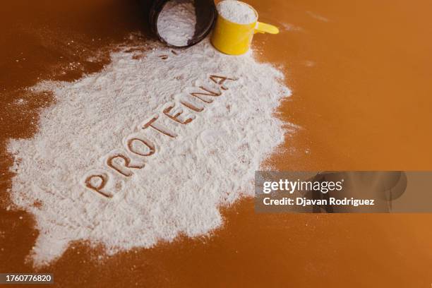 powder scattered with the text written in spanish 'creatina'. - protein shake stock-fotos und bilder