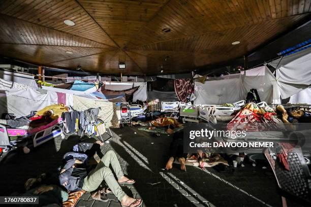 People wait in tent shelters in the darkness as fuel for electricity generation runs out, outside Al-Shifa hopsital in Gaza City early on November 3...