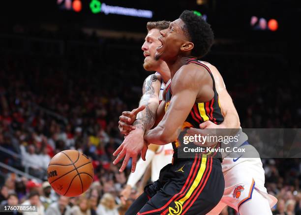 De'Andre Hunter of the Atlanta Hawks draws a foul by Isaiah Hartenstein of the New York Knicks during the fourth quarter at State Farm Arena on...