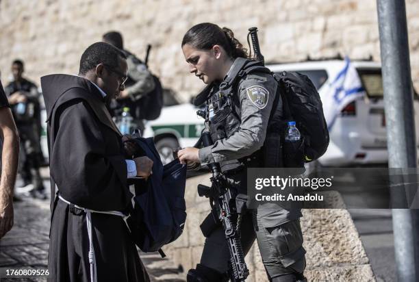 Israeli forces check the ID cards of Muslims within security measures as Muslims perform Friday prayers after Israeli authorities barred Palestinians...