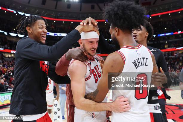 Alex Caruso of the Chicago Bulls celebrates with teammates after defeating the Toronto Raptors in overtime at the United Center on October 27, 2023...