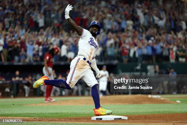 Adolis García of the Texas Rangers celebrates as he rounds the bases after hitting a home run in the 11th inning to beat the Arizona Diamondbacks 6-5...