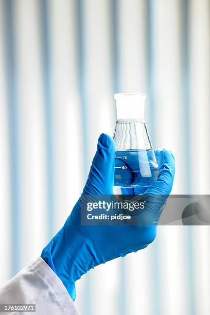 hombre que agarra de erlenmeyer matraz cónico xxxl - matraz fotografías e imágenes de stock