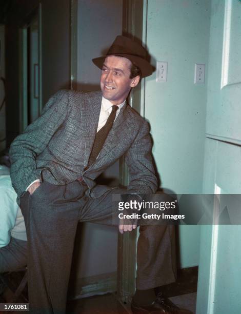 American actor Jimmy Stewart resting one arm on his knee, 1940s.