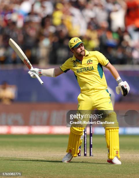 Travis Head of Australia celebrates as he raises his bat after reaching his century after scoring 100 runs during the ICC Men's Cricket World Cup...