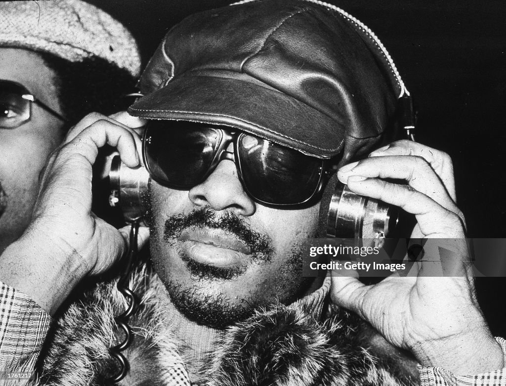 Stevie Wonder listening to headphones