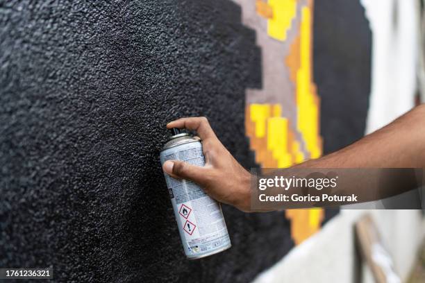 hand of graffiti artist spraying a wall - vandalism 個照片及圖片檔