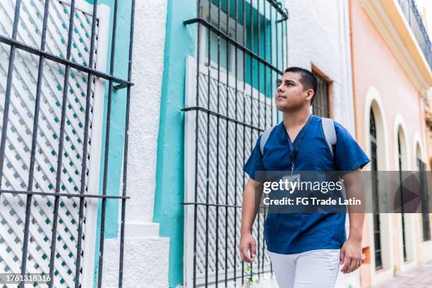 male nurse walking at the street - district nurse stock pictures, royalty-free photos & images