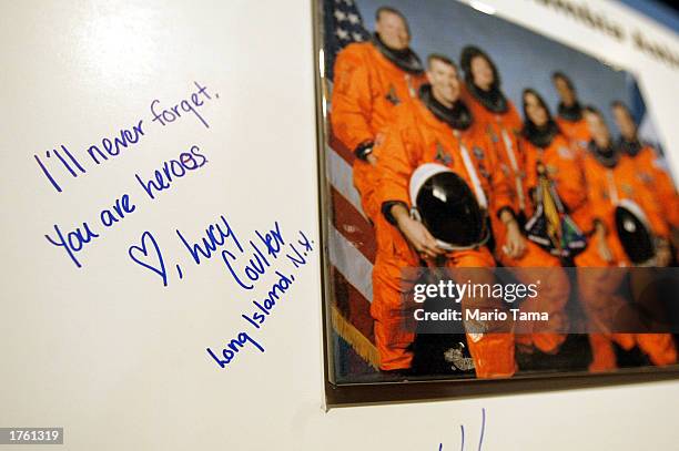 Message reading "I'll Never Forget. You Are Heroes." is written next to a photograph of the astronauts who were killed aboard the Space Shuttle...