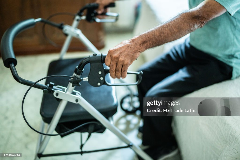 Primo piano di un uomo anziano con un deambulatore a casa