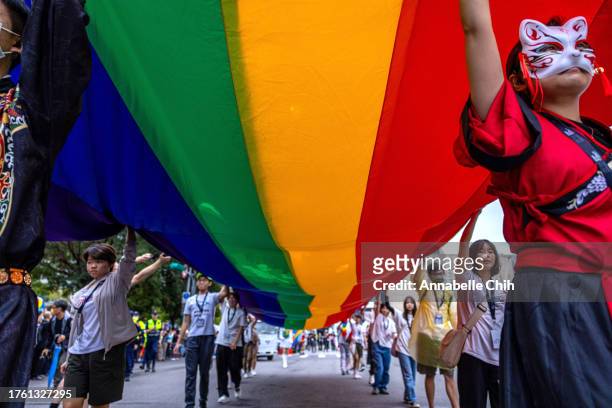 People carry a large rainbow flag during the parade of Taiwan Pride 2023 on October 28, 2023 in Taipei, Taiwan. The event, held in Taiwan annually,...