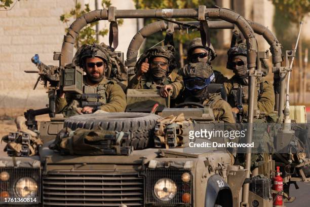 An Israeli soldier gives a thumbs-up gesture as Israeli troops move near the border with Gaza on October 28, 2023 in Sderot, Israel. In the wake of...