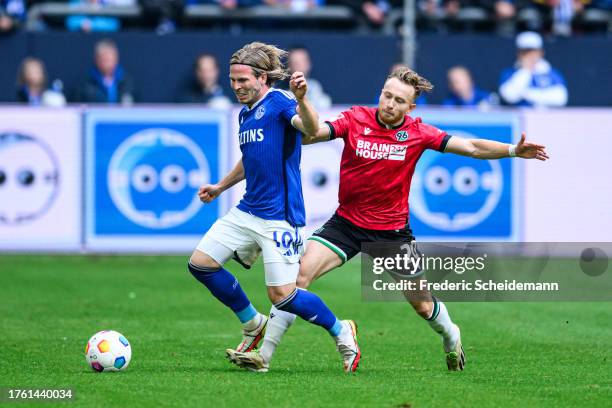 Lino Tempelmann of Schalke is challenged by Cedric Teuchert of Hannover during the Second Bundesliga match between FC Schalke 04 and Hannover 96 at...