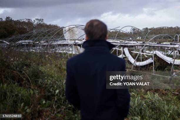 France's President Emmanuel Macron looks at the damages as he visits a farm in a region hit by Storm Ciaran in Plougastel-Daoulas, western France, on...