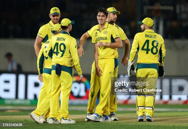 Pat Cummins of Australia celebrates with teammates after taking the wicket of Matt Henry of New Zealand during the ICC Men's Cricket World Cup India...