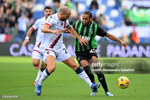 Lorenzo De Silvestri of Bologna FC competes for the ball with Armand Laurienté of US Sassuolo during the Serie A TIM match between US Sassuolo and...