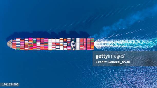 aerial top view large cargo ship vessel loaded with containers sailing in sea. - cargo ship stock pictures, royalty-free photos & images