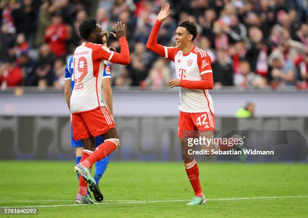 Jamal Musiala of Bayern Munich celebrates with Alphonso Davies of Bayern Munich after scoring the team's third goal during the Bundesliga match...