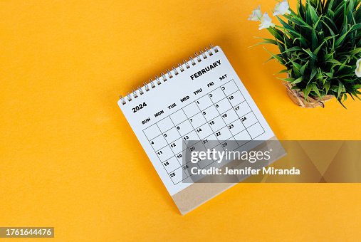 February 2024 desk calendar on yellow background. Directly above. Flat lay. February 2024 desk calendar on yellow background. Directly above. Flat lay.