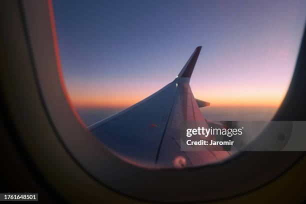 view through airplane window during flight at sunset - plane stock pictures, royalty-free photos & images