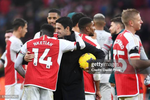 Eddie Nketiah of Arsenal and Mikel Arteta, Manager of Arsenal, embrace at full-time following their team's victory in the Premier League match...
