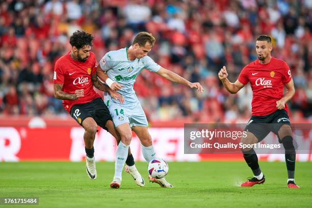 Samu Costa of RCD Mallorca competes for the ball with Juanmi Latasa of Getafe CF during the LaLiga EA Sports match between RCD Mallorca and Getafe CF...